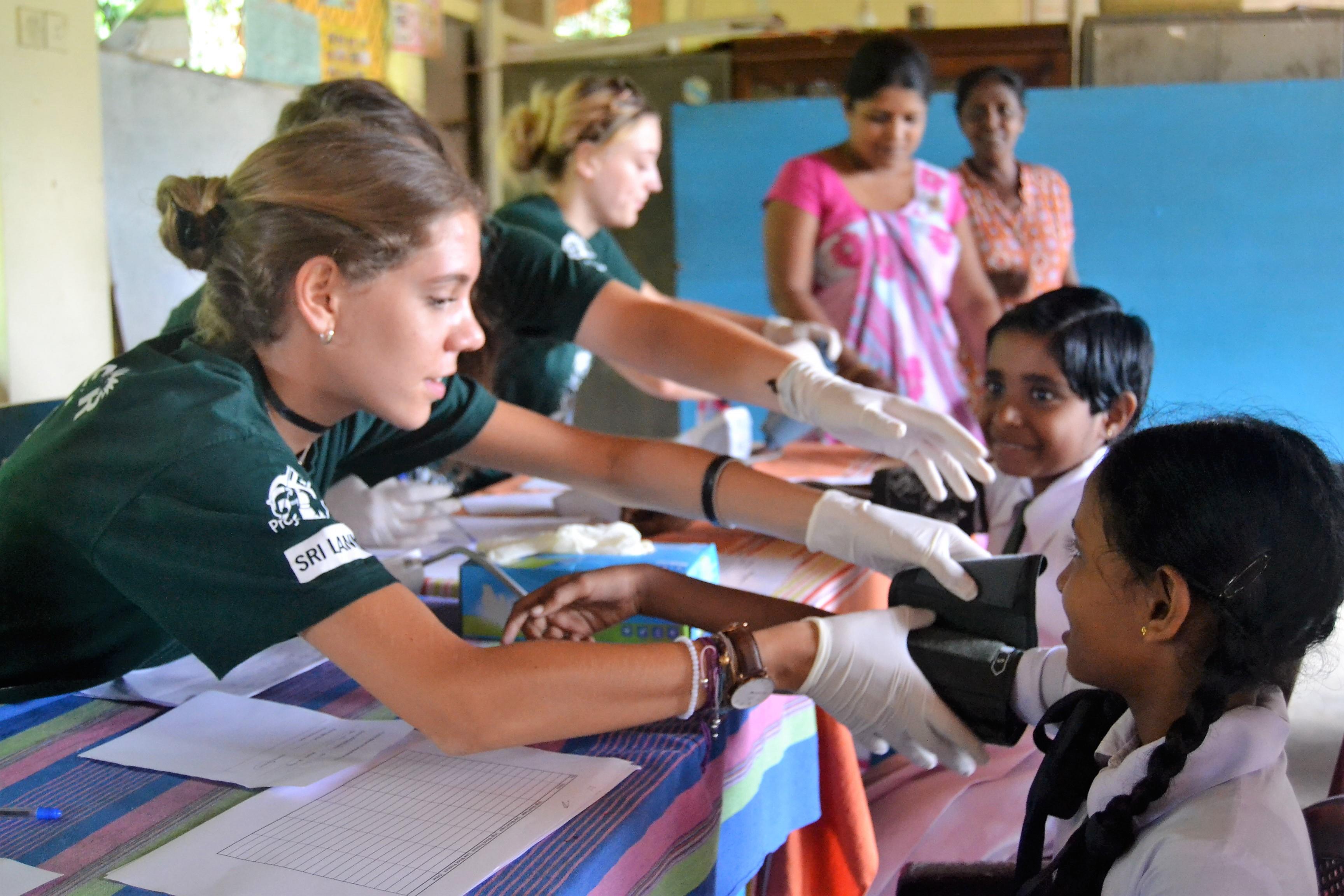 A group of interns measure blood pressure levels of local children and gain work experience as part of their public health internship in Sri Lanka. A group of interns are pictured measuring blood pressure levels as part of their public health internship in Sri Lanka.